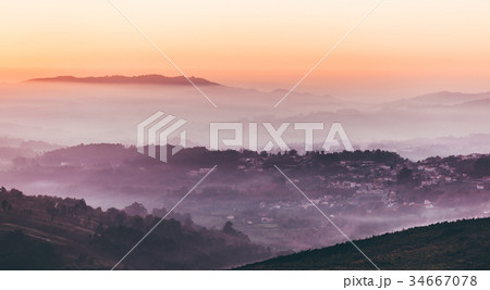 Sunset sky above layers of foggy mountains Sunset sky above layers of foggy mountains 34667078