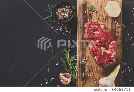 Rib eye steak and spices on wood at black 34668711