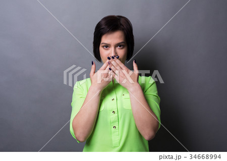 Scared woman covering mouth with hands Scared woman covering mouth with hands 34668994