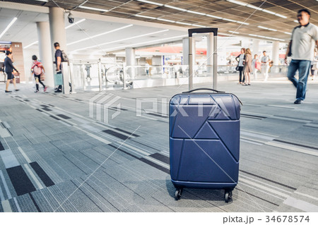 Suitcases in airport terminal with traveler 34678574
