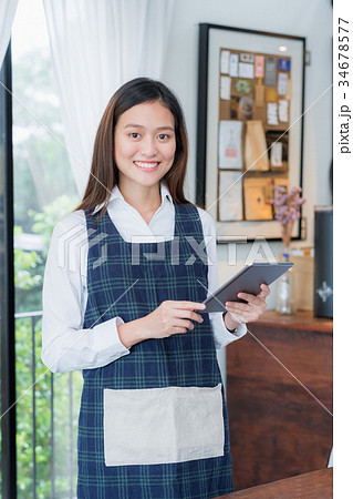 Asian female barista hold tablet computer 34678577