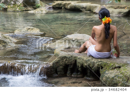 woman with jar sitting by the creek 34682404