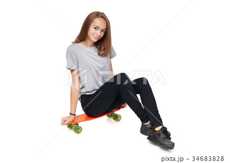 Teen girl in full length sitting on skate board Teen girl in full length sitting on skate board 34683828