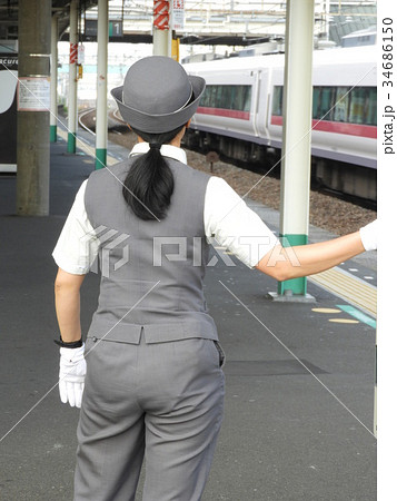 常磐線の特急列車を見つめる女性車掌さんの写真素材