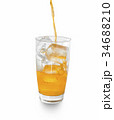 orange soda pouring into glass with ice. 34688210