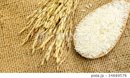Jasmine rice in a ladle on a wooden table. Jasmine rice in a ladle on a wooden table. 34689576