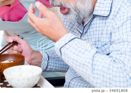 食事 若い看護師もしくは介護士とおじいちゃん 老人ホーム デイケアセンター 食事 若い看護師もしくは介護士とおじいちゃん 老人ホーム デイケアセンター 34691808