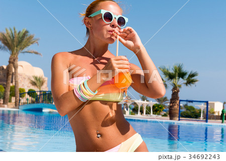 Happy young woman with cocktail 34692243