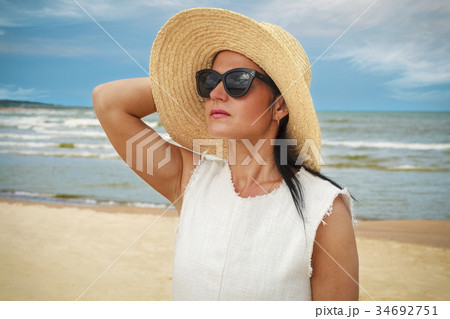 Woman in straw hat on the beach Woman in straw hat on the beach 34692751