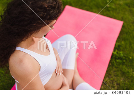 Pregnant woman with hands over tummy. 34693402