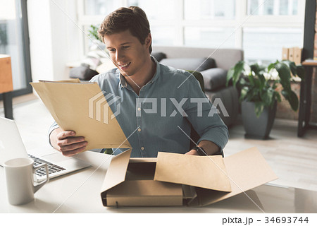 Positive young male is laboring in cozy office 34693744