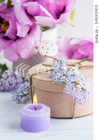 Lit candle, peonies and lilac flowers Lit candle, peonies and lilac flowers 34693905