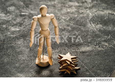 Wooden dummy stands near the stack of wooden stars Wooden dummy stands near the stack of wooden stars 34693959