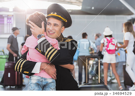 Hilarious aviator embracing little boy Hilarious aviator embracing little boy 34694529