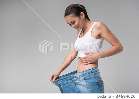 Cheerful young woman is satisfied with her diet Cheerful young woman is satisfied with her diet 34694626