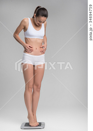Thin young woman is satisfied with result of Thin young woman is satisfied with result of 34694759
