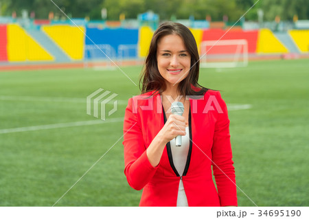 Young girl TV reporter is broadcasting Young girl TV reporter is broadcasting 34695190