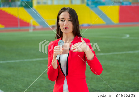 Young girl TV reporter is broadcasting Young girl TV reporter is broadcasting 34695208