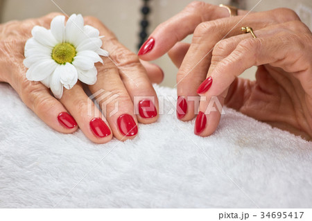 Female hands with manicure on towel. Female hands with manicure on towel. 34695417