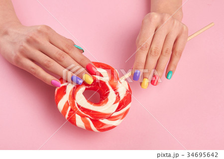 Female hands with large lollypop. Female hands with large lollypop. 34695642