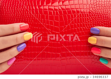 Close up red bag in manicured hands. 34696337