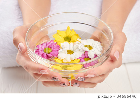 Bowl with chrysanthemums in female hands. Bowl with chrysanthemums in female hands. 34696446