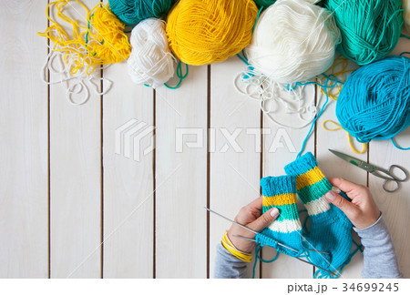 A woman knits knit socks with children's knitting  34699245