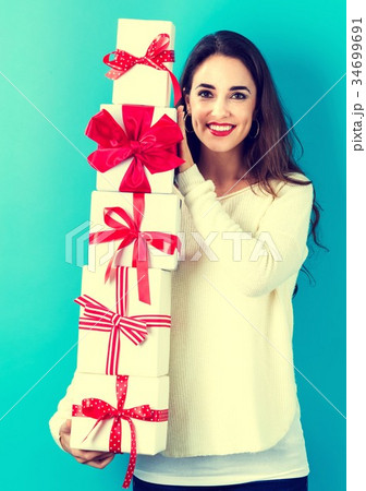 Young woman holding Christmas gifts Young woman holding Christmas gifts 34699691