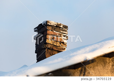 Snow on the roof of the house at sunset Snow on the roof of the house at sunset 34703119