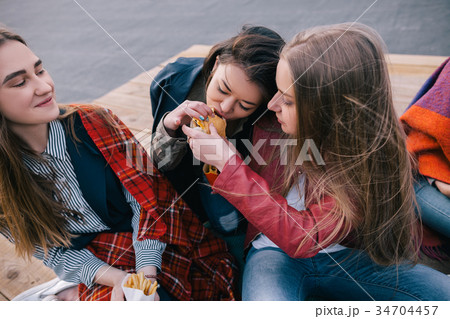 Two girls sharing one burger. Close friendship 34704457