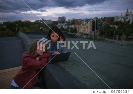 Girlfriends watching a movie on a laptop Girlfriends watching a movie on a laptop 34704584