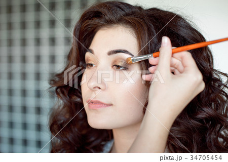 Eye makeup woman applying eyeshadow powder. Make Eye makeup woman applying eyeshadow powder. Make 34705454