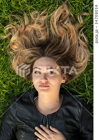 Teenage girl laying in grass Teenage girl laying in grass 34709034