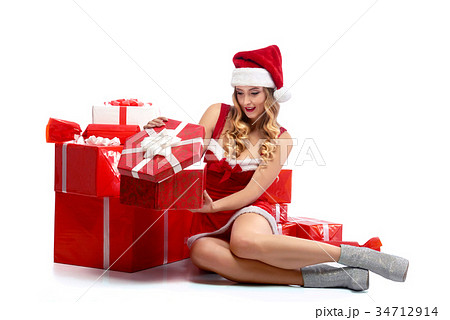 Young attractive female opening Christmas presents 34712914