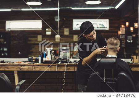 Crop barber doing haircut for client Crop barber doing haircut for client 34713476