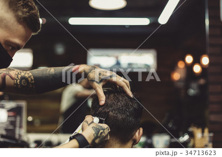 Barber shaving man in chair 34713623