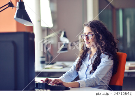 Portrait of smiling pretty young business woman in 34715642