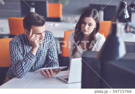 Young Casual business couple using computer in the Young Casual business couple using computer in the 34715766