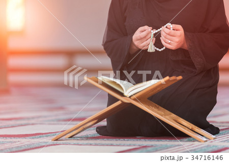 Young muslim woman praying in mosque 34716146