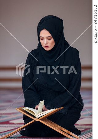 Young muslim woman praying in mosque 34716152