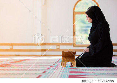 Young muslim woman praying in mosque 34716499