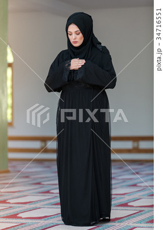 Young muslim woman praying in mosque 34716551