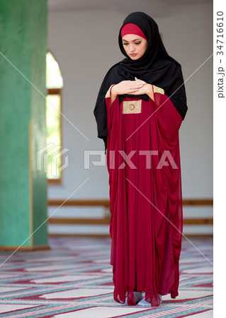 Young muslim woman praying in mosque 34716610