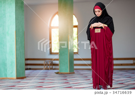 Young muslim woman praying in mosque 34716639