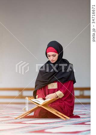 Young muslim woman praying in mosque 34716671