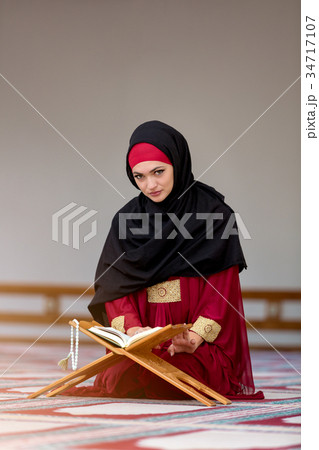 Young muslim woman praying in mosque 34717107