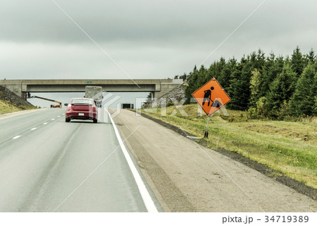 Orange construction worker sign at road into the 34719389