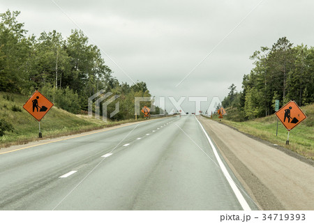 Orange construction worker sign at road into the Orange construction worker sign at road into the 34719393