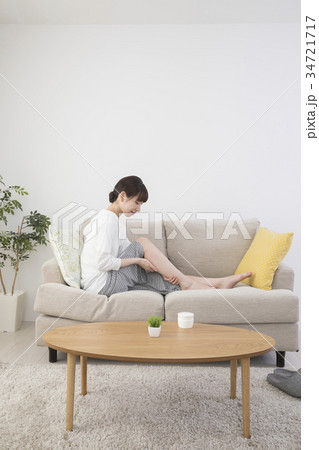自宅で足をマッサージする女性 自宅で足をマッサージする女性 34721717