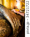 Female hands are gilded Buddha statue 34721722